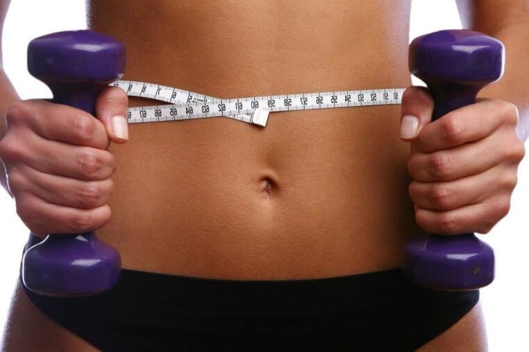 Fitness dumbbells in the hands of fitness girl